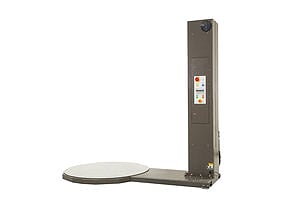 A tall, vertical machine with a round platform at its base.