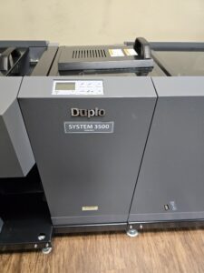 Close-up of a Duplo DC-616i paper collator machine.
