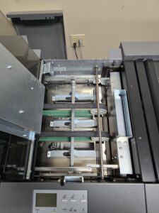 Interior view of a partially disassembled printer showing rollers and mechanical parts.