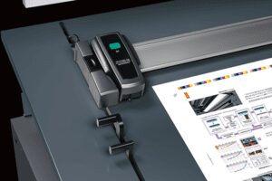 A digital paper cutter trimming a brochure.