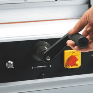 Hand adjusting a control knob on industrial equipment.