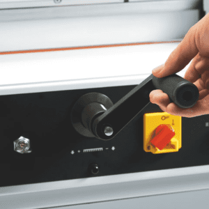Hand adjusting a control knob on industrial equipment.