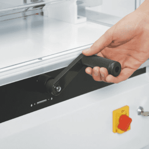 Hand operating a lever on industrial equipment.