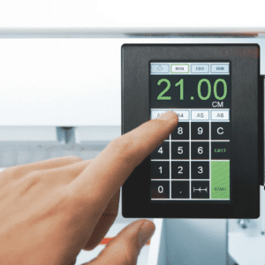 A hand operating a digital weighing scale with a touchscreen.