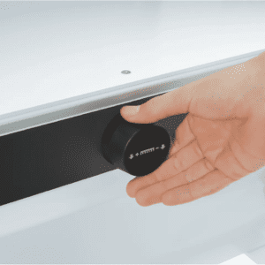 Hand adjusting a knob on a white appliance or device.